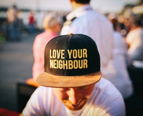 Man wearing a hat reviewing financial paperwork, representing hardship support season and access to relief programs for families facing financial challenges.